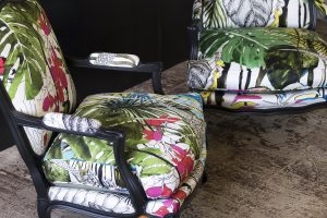 Détail d'une bergère Louis XV rénovée avec des motifs végétaux et floraux.