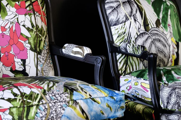 Détail d'une bergère Louis XV rénovée avec des motifs végétaux et floraux.