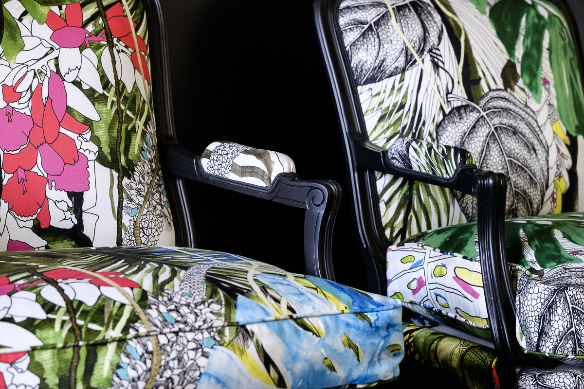 Détail d'une bergère Louis XV rénovée avec des motifs végétaux et floraux.