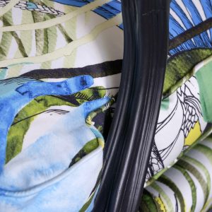 Détail d'une bergère Louis XV rénovée avec des motifs végétaux et floraux.