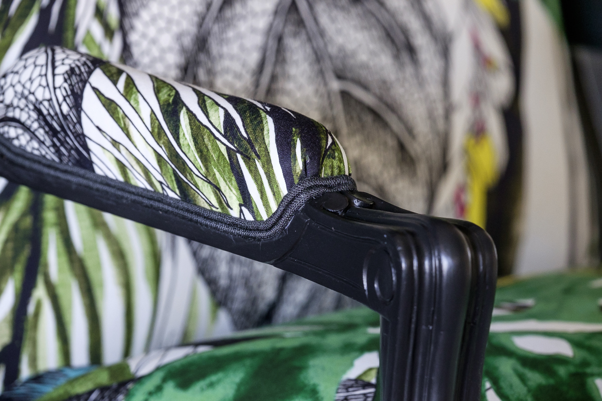 Détail d'une bergère Louis XV rénovée avec des motifs végétaux et floraux.