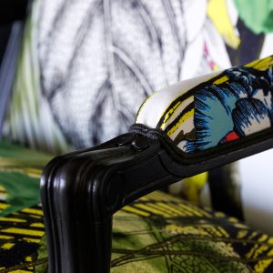 Détail d'une bergère Louis XV rénovée avec des motifs végétaux et floraux.