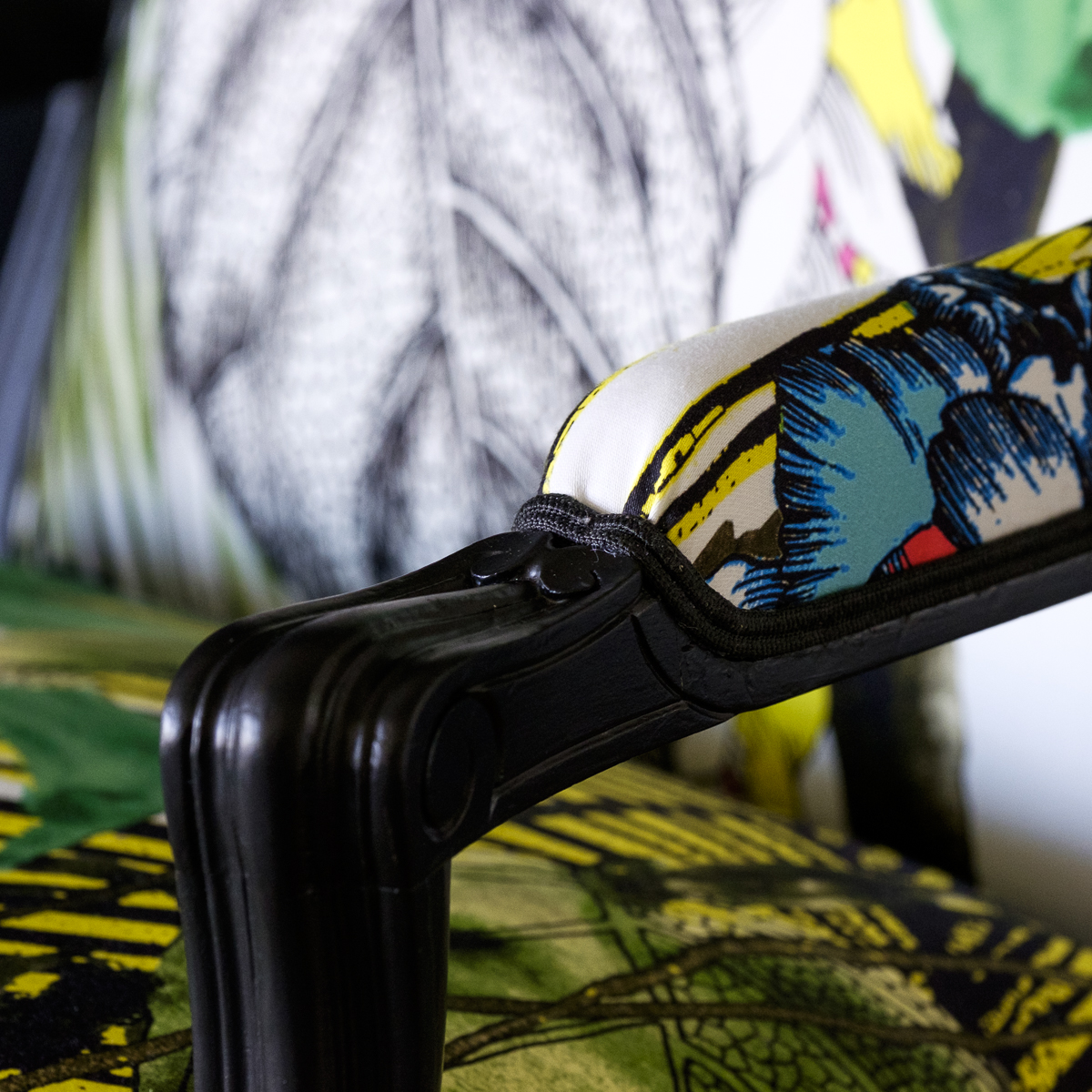 Détail d'une bergère Louis XV rénovée avec des motifs végétaux et floraux.