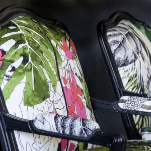 Détail d'une bergère Louis XV rénovée avec des motifs végétaux et floraux.