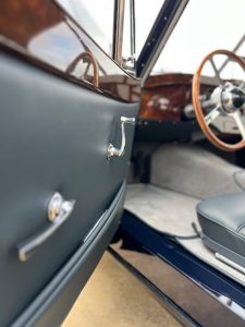 Intérieur d'une Jaguar XK120, détail de la portière en cuir et des tapis en tissu.
